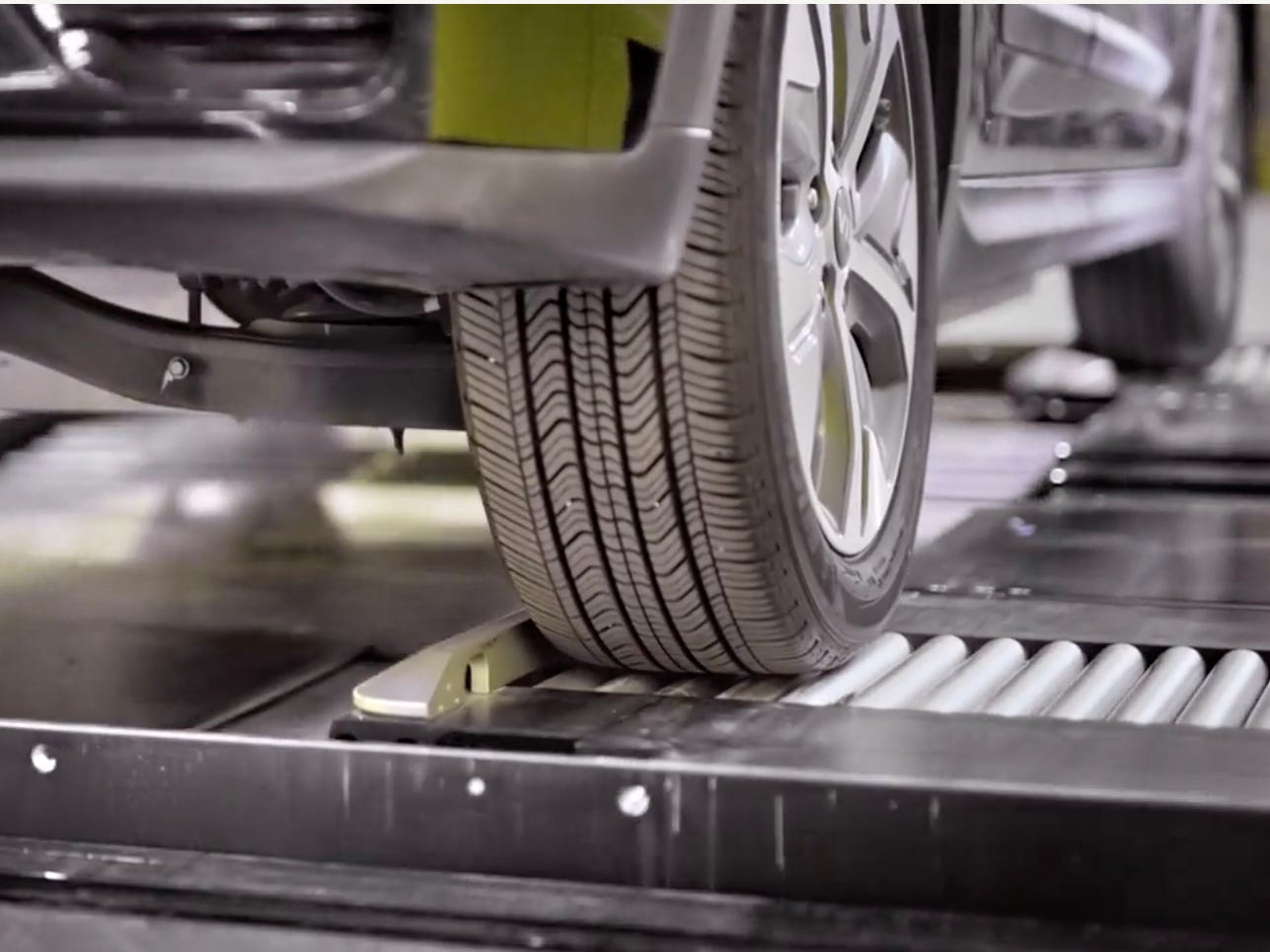 An electric vehicle's tires is positioned correctly in the station to receive the swap.