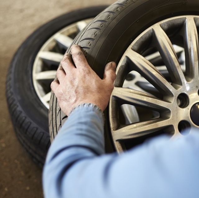 garage mechanic examining car tyre