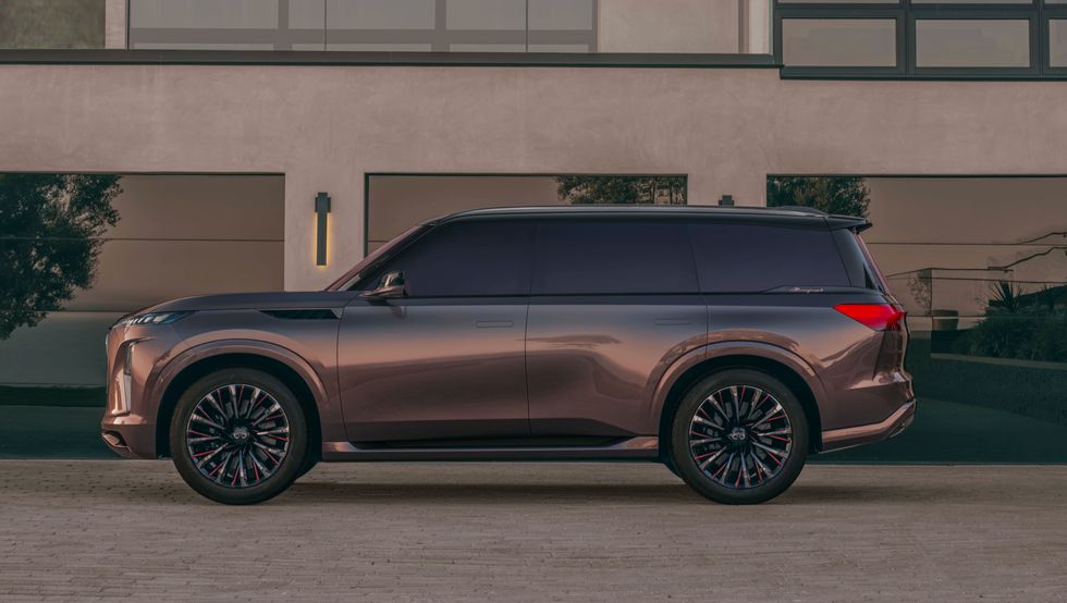 2024 infiniti qx monograph from the side against a modern mansion