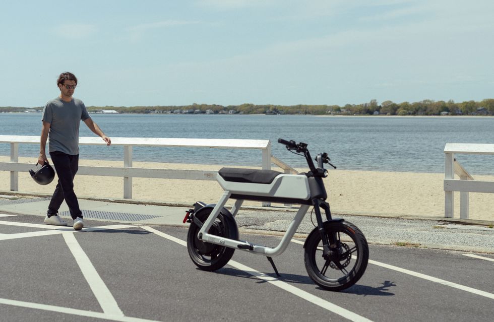 pave motors bk scooter with guy walking up to it near beachside