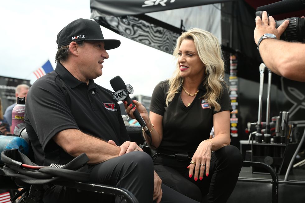 a man and woman sitting on a chair with microphones